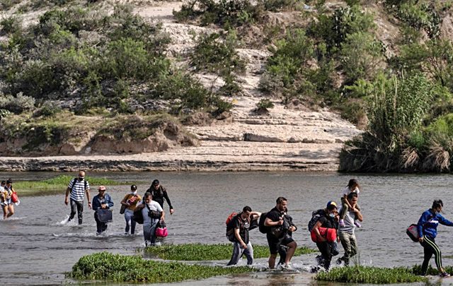 FOTO DE ARCHIVO. Familias de migrantes solicitantes de asilo de Venezuela caminan en el agua mientras cruzan el río Bravo hacia Estados Unidos desde México, en Del Río, Texas, Estados Unidos. 26 de mayo de 2021. REUTERS/Go Nakamura