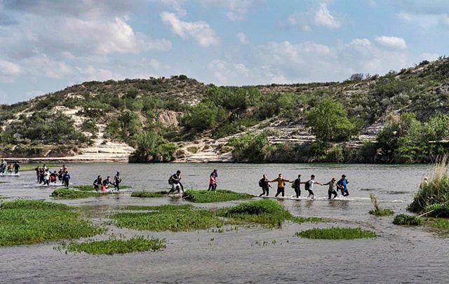 FOTO DE ARCHIVO: Familias de migrantes venezolanos que buscan asilo caminan en el agua mientras cruzan el río Grande hacia Estados Unidos desde México en Del Rio, Texas, Estados Unidos, 26 de mayo de 2021. REUTERS / Go Nakamura / Foto de archivo